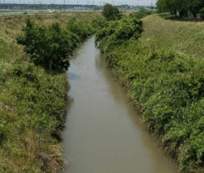 田畑の中を流れる川の写真