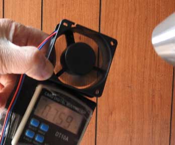 パソコン用送風ファンを風で回して発電する電気を測っているところの写真